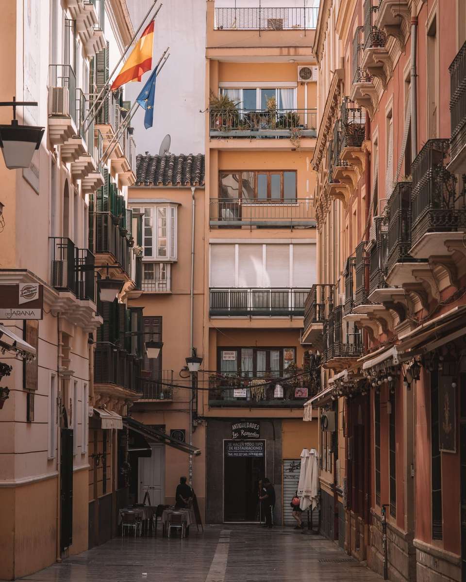 Calle estrecha de Málaga entre edificios con balcones