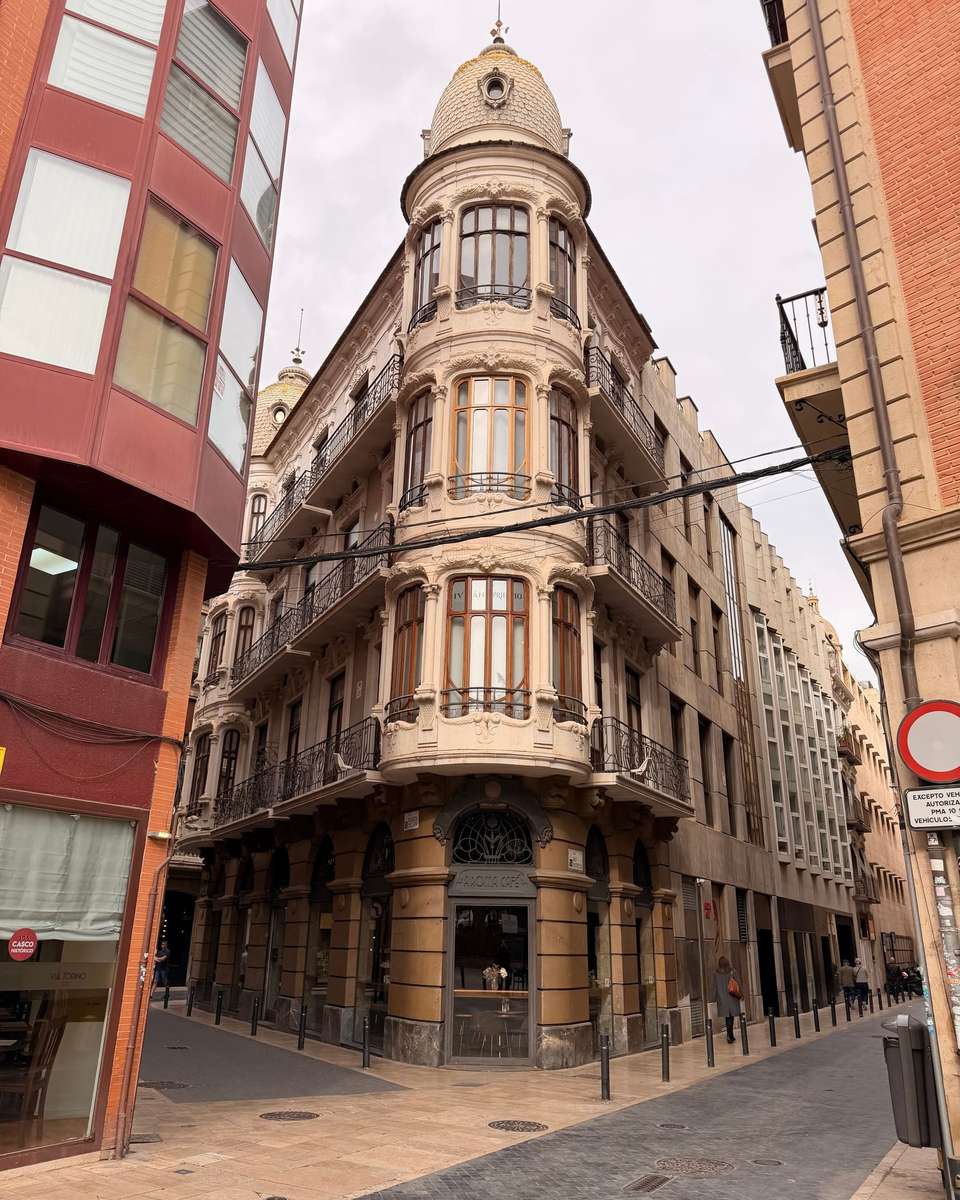 Edificio histórico de esquina con balcones y miradores en una calle de Murcia