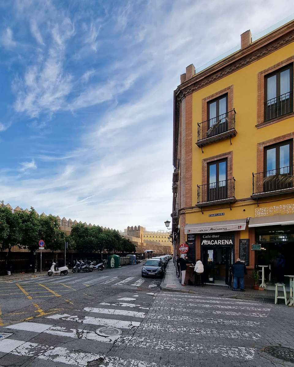 Edificio de esquina con balcones junto a una calle de Sevilla
